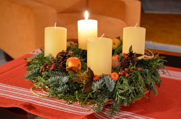 Adventskranz mit einer brennenden Kerze